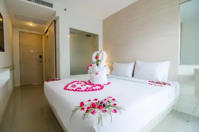 a bed with a bunny on it with flowers on it at Mirage Express Patong Phuket Hotel in Patong Beach