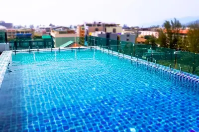 a large blue swimming pool on top of a building at Mirage Express Patong Phuket Hotel in Patong Beach