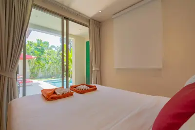 a bedroom with a bed and a large window at 3BR Villa with Private Pool in Trichada Sky at Bangtao Beach in Bang Tao Beach