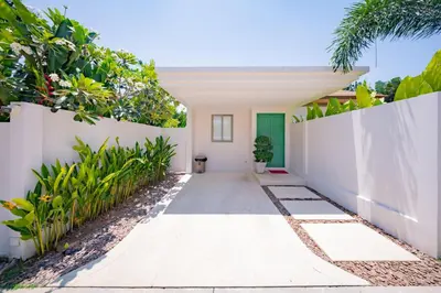 a courtyard of a house with a white fence and plants at 3BR Villa with Private Pool in Trichada Sky at Bangtao Beach in Bang Tao Beach