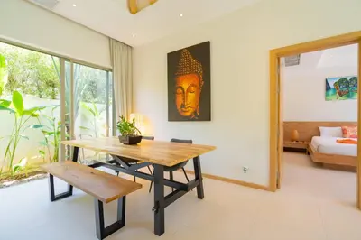 a dining room with a wooden table and a bed at 3BR Villa with Private Pool in Trichada Sky at Bangtao Beach in Bang Tao Beach