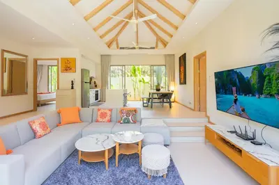 a living room with a white couch and a tv at 3BR Villa with Private Pool in Trichada Sky at Bangtao Beach in Bang Tao Beach