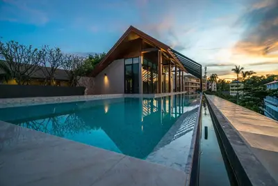 a swimming pool in front of a house at Apartment at Palmyrah Surin by Lofty in Surin Beach