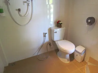 a bathroom with a toilet and a shower at Kingsacre in Nai Yang Beach