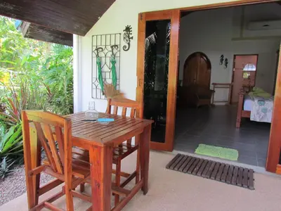 a wooden table and chairs on a porch at Kingsacre in Nai Yang Beach