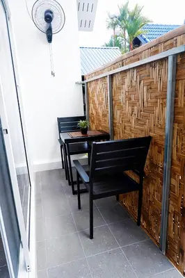 a balcony with two benches and a table at Kingsacre in Nai Yang Beach