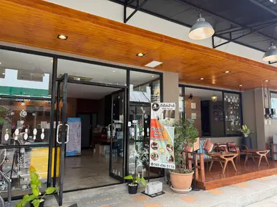 a store front with glass doors and a table and chairs at Dfeel House in Patong Beach