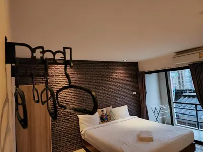 a bedroom with a bed and a brick wall at Dfeel House in Patong Beach