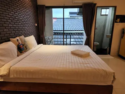 a bedroom with a large white bed with a view at Dfeel House in Patong Beach