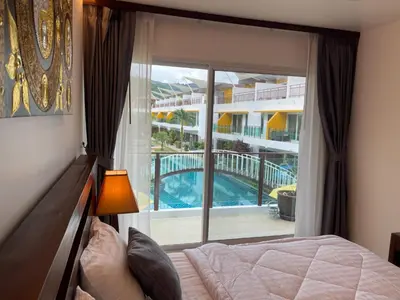 a bedroom with a bed and a view of a pool at Villa Luxe AP06 in Kamala Beach