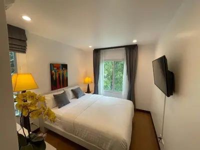 a bedroom with a white bed and a television at Villa Luxe AP06 in Kamala Beach