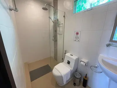 a white bathroom with a toilet and a sink at Villa Luxe AP06 in Kamala Beach