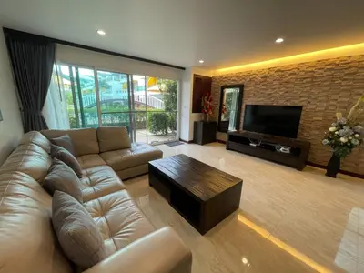 a living room with a leather couch and a television at Villa Luxe AP06 in Kamala Beach