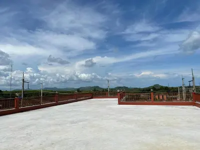 a wooden bridge with a cloudy sky in the background at บ้านบัว เมืองใหม่ Baanbua Muangmai in Thalang