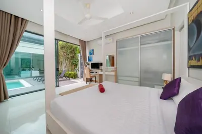 a bedroom with a large white bed with purple pillows at Relax & Enjoy Stay! Elegant 3BR Pool Villa Talosy in Rawai Beach