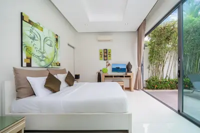 a bedroom with a white bed and a sliding glass door at Relax & Enjoy Stay! Elegant 3BR Pool Villa Talosy in Rawai Beach