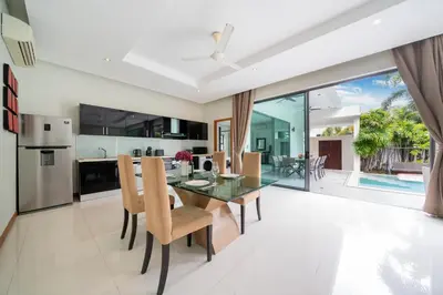 an open kitchen and dining room with a glass table and chairs at Relax & Enjoy Stay! Elegant 3BR Pool Villa Talosy in Rawai Beach