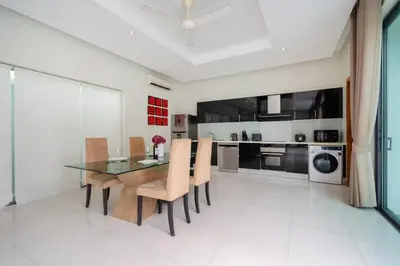 a dining room with a glass table and chairs at Relax & Enjoy Stay! Elegant 3BR Pool Villa Talosy in Rawai Beach