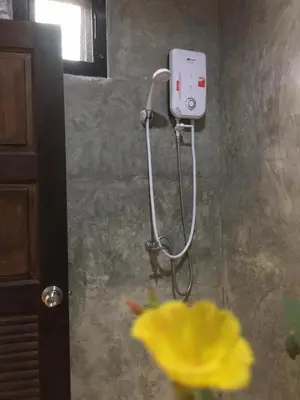 a shower in a bathroom with a yellow flower at Rawai Whale Resort in Rawai Beach