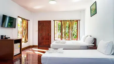 a hotel room with two beds and a television at Doo Dee Boutique Resort by Swiss Chalet in Ao Nang Beach
