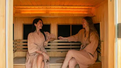 two women in robes sitting in a sauna at Hilltop Wellness Resort Phuket in Phuket Town