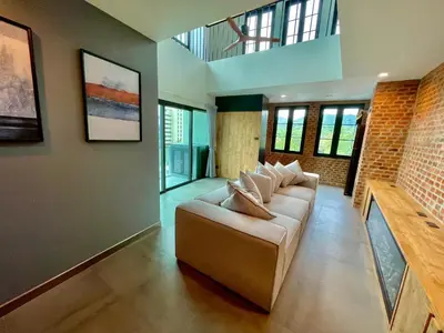 a living room with a couch and some windows at Room Actually Service Apartment in Karon Beach