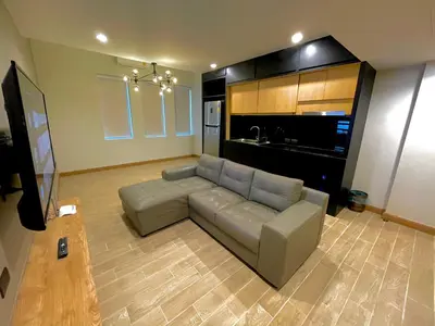 a living room with a couch and a kitchen at Room Actually Service Apartment in Karon Beach