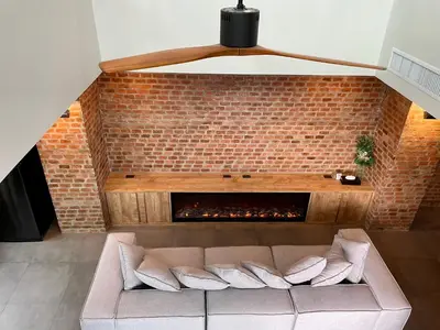 a living room with a couch and a brick fireplace at Room Actually Service Apartment in Karon Beach