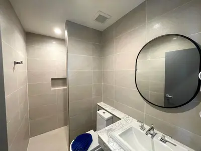 a bathroom with a sink and a mirror and a toilet at Room Actually Service Apartment in Karon Beach