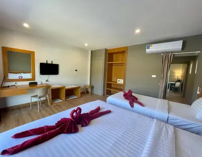 a hotel room with two beds with red bows on them at Room Actually Service Apartment in Karon Beach