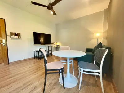 a living room with a table and chairs and a couch at Room Actually Service Apartment in Karon Beach