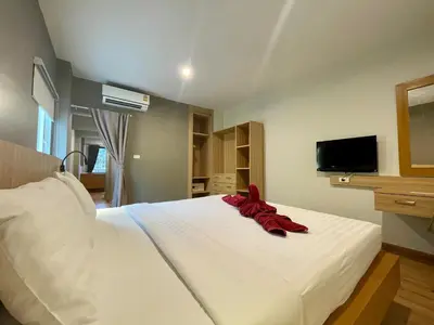 a bedroom with a white bed with a red ribbon on it at Room Actually Service Apartment in Karon Beach