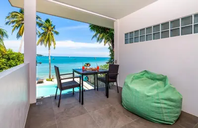 a dining room with a table and a view of the ocean at Mango Tree Villa in Panwa Beach