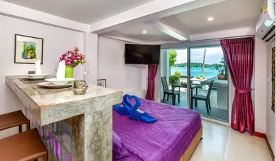 a living room with a purple bed and a table at Mango Tree Villa in Panwa Beach