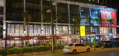 a white car parked in front of a building at night at Tour De Phuket Hotel - SHA Plus in Thalang