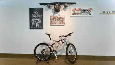 a bike parked against a white wall with clocks at Tour De Phuket Hotel - SHA Plus in Thalang