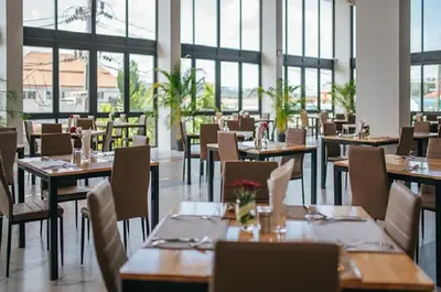 a restaurant with wooden tables and chairs and windows at Tour De Phuket Hotel - SHA Plus in Thalang