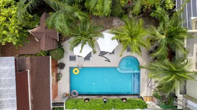 an overhead view of a swimming pool with palm trees at Baan Sailom Hotel Phuket - Sha Extra Plus in Karon Beach