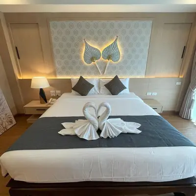a bedroom with a bed with two heart shaped towels at Baan Sailom Hotel Phuket - Sha Extra Plus in Karon Beach