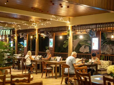 a group of people sitting at tables in a restaurant at Baan Sailom Hotel Phuket - Sha Extra Plus in Karon Beach