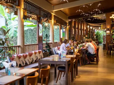a group of people sitting at tables in a restaurant at Baan Sailom Hotel Phuket - Sha Extra Plus in Karon Beach