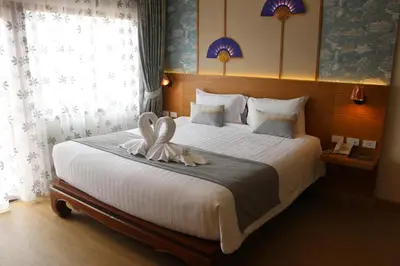 a bedroom with a bed with two swans on it at Baan Sailom Hotel Phuket - Sha Extra Plus in Karon Beach