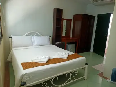 a bedroom with a bed with two white shoes on it at Kata Garden Resort SHA Extra Plus in Kata Beach