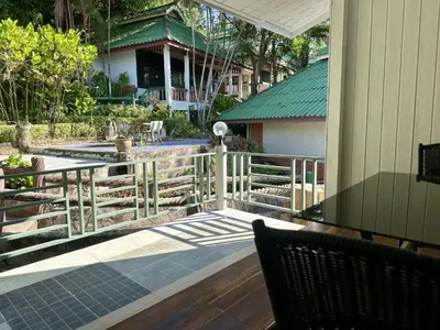 a porch with a fence and a table and chairs at Kata Garden Resort SHA Extra Plus in Kata Beach