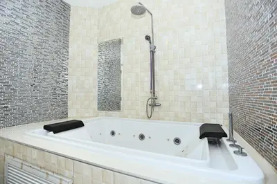 a white bath tub in a bathroom with a mirror at Lucky Sun Patong in Patong Beach
