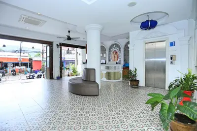 a lobby with a chair in the middle of a building at Lucky Sun Patong in Patong Beach