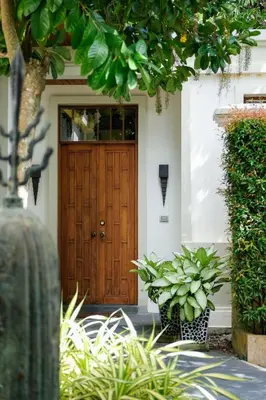 a wooden front door of a house with plants at Villa Salika in Rawai Beach