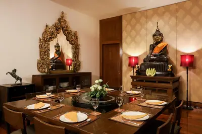 a dining room with a table and a statue at Villa Salika in Rawai Beach