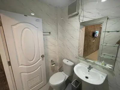a white bathroom with a toilet and a sink at MONDEE House @The Airport in Thalang