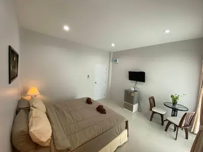 a bedroom with a bed with a teddy bear on it at MONDEE House @The Airport in Thalang